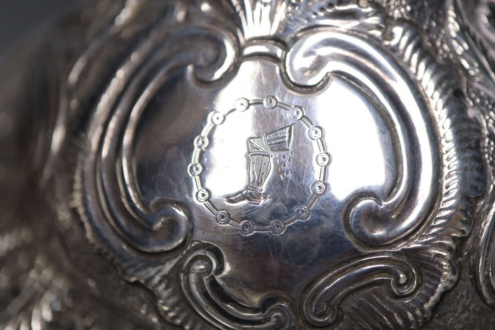 A pair of late George III silver candlesticks, with later embossed decoration, Soloman Hougham, London 1817,